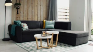 Sofá grande com chaise em sala de estar clara, com tapete e mesas de centro